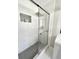 Walk-in shower featuring marble tile walls, mosaic floors, and a built-in shelf at 3845 Pebble Beach Dr, Atlanta, GA 30349