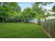 Spacious backyard with green lawn, mature trees, and home view at 877 Mclendon Dr, Scottdale, GA 30079