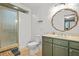 Bathroom featuring a glass shower, toilet, and green vanity with an ornate mirror at 877 Mclendon Dr, Scottdale, GA 30079