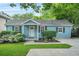 Charming blue house with a well-maintained lawn, garden and welcoming front porch at 877 Mclendon Dr, Scottdale, GA 30079