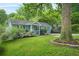 Charming blue home with a well-manicured front yard and vibrant landscaping at 877 Mclendon Dr, Scottdale, GA 30079
