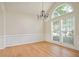 Bright dining room with hardwood floors, classic chandelier, large windows, and paneled walls at 1460 Chamirey Sw Dr, Marietta, GA 30008
