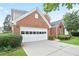 This is a beautiful view of the left side of the brick home and attached white two-car garage at 1460 Chamirey Sw Dr, Marietta, GA 30008