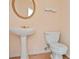 Half-bath with white pedestal sink, updated fixtures, and decorative mirror at 1460 Chamirey Sw Dr, Marietta, GA 30008