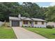 Inviting single-story home with gray garage, concrete driveway, and meticulously landscaped front yard at 2784 Oxford Dr, Decatur, GA 30034