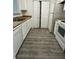 Galley kitchen featuring white appliances, tile countertops, and new flooring at 3609 Ginnis Rd, Atlanta, GA 30331