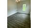 Bright living room with wood-look floors, a window, and a chandelier at 3609 Ginnis Rd, Atlanta, GA 30331