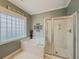 Bathroom featuring soaking tub, glass block window, and a shower behind a glass door at 557 Pringle Dr, Suwanee, GA 30024