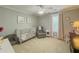 Neutral Bedroom with white crib, accent wall art, and chair by window at 557 Pringle Dr, Suwanee, GA 30024