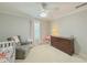 Charming Bedroom featuring a crib, comfortable armchair, dresser, and playful decor at 557 Pringle Dr, Suwanee, GA 30024