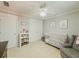 Cozy Bedroom with gray walls, ceiling fan, white crib, storage shelves, and comfortable armchair at 557 Pringle Dr, Suwanee, GA 30024