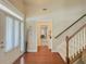 Foyer with wood floor, light walls, a staircase, and a door with sheer curtains at 557 Pringle Dr, Suwanee, GA 30024