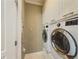 Modern laundry room with white cabinets, countertop, and stacked washer and dryer at 557 Pringle Dr, Suwanee, GA 30024