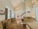 Bright living room featuring vaulted ceilings, a cozy seating area, and views of the staircase at 557 Pringle Dr, Suwanee, GA 30024