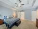 This main bedroom has carpet, a fan, blue walls, and white trim on the ceiling at 557 Pringle Dr, Suwanee, GA 30024