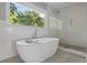 Bright bathroom with large tub under window, glass shower, and decorative flooring at 984 Ridgecrest Se Dr, Smyrna, GA 30080
