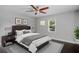 Bedroom features large bed with a tufted headboard, ceiling fan, and a dark laminate floor at 984 Ridgecrest Se Dr, Smyrna, GA 30080