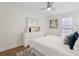 Bright bedroom featuring a neutral palette with white furniture, decorative pillows on the bed, and wood flooring at 1166 Booth Sw Rd # 301, Marietta, GA 30008