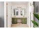 This bathroom offers green cabinets, gold accents, a double vanity and two white doors at 1348 Sheffield Glen Ne Way # 8, Atlanta, GA 30329