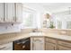Bright kitchen with white cabinets, golden hardware, granite countertops and a stainless steel dishwasher at 1348 Sheffield Glen Ne Way # 8, Atlanta, GA 30329