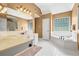 Bright main bathroom with a tiled tub, dual vanities, and ample natural light with a large glass block window at 2459 Chestnut Lndg, Atlanta, GA 30360