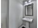 Powder room featuring a pedestal sink, modern faucet, and stylish mirror at 4232 Perimeter E Park # 110, Atlanta, GA 30341