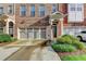 Brick townhome featuring a two-car garage and well-maintained landscaping at 4232 Perimeter E Park # 110, Atlanta, GA 30341