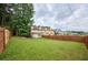 Spacious backyard with lush green grass, mature trees, and wooden fence at 5567 Executive Way, Norcross, GA 30071