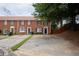 Brick townhome featuring a private driveway, manicured lawn, and a traditional-style entrance at 5567 Executive Way, Norcross, GA 30071