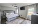 Comfortable main bedroom features a large bed, ceiling fan, mounted television, and bright windows at 5567 Executive Way, Norcross, GA 30071