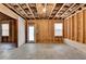 An unfinished basement featuring stud framing, windows, and an exterior door providing a blank canvas for customization at 68 Hardy Water Dr, Lawrenceville, GA 30045