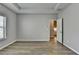 A bedroom featuring hardwood floors, grey paint and a tray ceiling, creating a serene and modern living space at 68 Hardy Water Dr, Lawrenceville, GA 30045