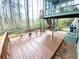 Elevated wooden deck with bench seating overlooks a wooded backyard. Screened-in porch access at 929 Hampton Nw Trl, Lilburn, GA 30047