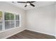 Bright bedroom features a ceiling fan, large window, and hardwood floors at 1704 Evenstad Way, Smyrna, GA 30080