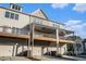 Rear view of three townhomes featuring balconies and garages with manicured landscaping at 1704 Evenstad Way, Smyrna, GA 30080