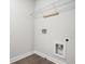 A laundry room with white walls, wood-look flooring, shelving, and hookups for a washing machine and dryer at 1704 Evenstad Way, Smyrna, GA 30080