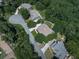 An aerial shot showcasing a beautiful home nestled among lush trees, featuring a well-manicured lawn and long driveway at 310 River Birch Ct, Canton, GA 30114
