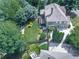 Aerial view of a home with a large backyard, a deck, mature trees, an outdoor playset and a driveway at 310 River Birch Ct, Canton, GA 30114