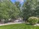 Serene backyard setting with a pergola seating area, mature trees, and lush greenery for privacy at 310 River Birch Ct, Canton, GA 30114