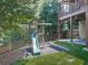 Backyard features a playset with slide and swings, nestled beside the home's covered deck at 310 River Birch Ct, Canton, GA 30114