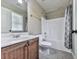 Bathroom with tiled floors, wood vanity, toilet, and tub with shower at 310 River Birch Ct, Canton, GA 30114