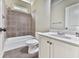 Well-lit bathroom featuring a vanity, sink, toilet, and shower with decorative tile at 310 River Birch Ct, Canton, GA 30114
