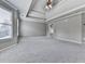 A spacious bedroom featuring plush carpet, a tray ceiling, and large windows for lots of natural light at 310 River Birch Ct, Canton, GA 30114