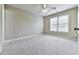Spacious bedroom with plush carpet, a ceiling fan, and a window offering natural light at 310 River Birch Ct, Canton, GA 30114