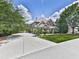 Beautiful two-story home with a well-manicured lawn, mature trees, and a long driveway on a sunny day at 310 River Birch Ct, Canton, GA 30114