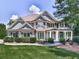 Beautiful two-story home featuring stone accents, lush landscaping, and a welcoming covered front porch at 310 River Birch Ct, Canton, GA 30114