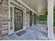 Inviting front porch with stone flooring, stone walls, and a stylish front door at 310 River Birch Ct, Canton, GA 30114