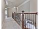 Upstairs hallway featuring carpet floors, wood and iron railing, and views to the downstairs at 310 River Birch Ct, Canton, GA 30114