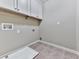 A laundry room featuring tile flooring, overhead cabinets, and plenty of available space at 310 River Birch Ct, Canton, GA 30114