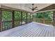 Cozy screened-in porch featuring a ceiling fan and white wood flooring that offers views of the wooded landscape at 310 River Birch Ct, Canton, GA 30114